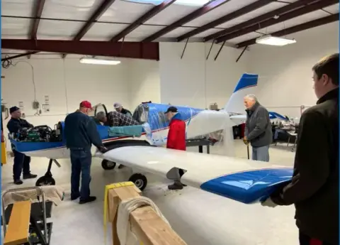 Members fitting the wings to the club airplane in the hangar