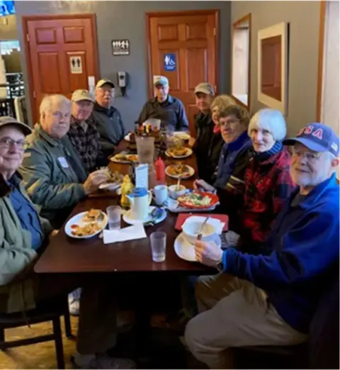 Members seated at a restaurant table
