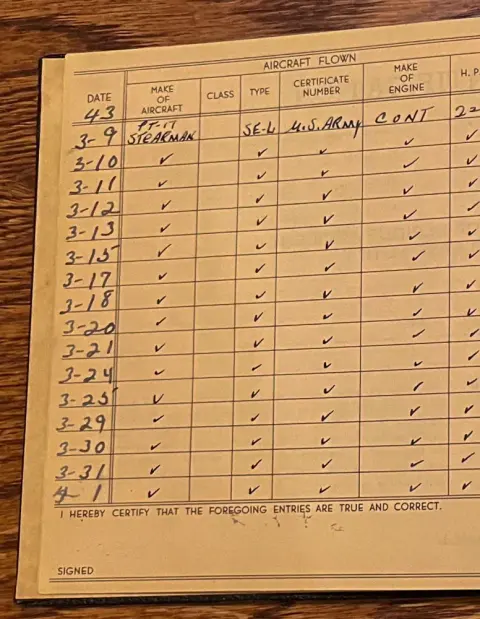 An open pilot logbook page with handwritten entries