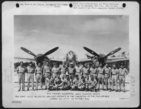 A World War II squadron photo of pilots in front of P-47 fighters