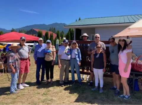 A group of people standing outdoors under trees