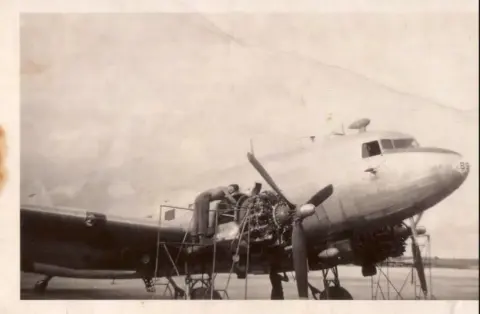 My grandfather working on a C-47 in Guam