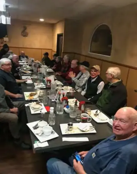 Chapter members seated along a long restaurant table