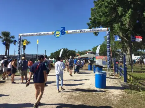 Crowd walking under the entrance arch at Sun 'n Fun