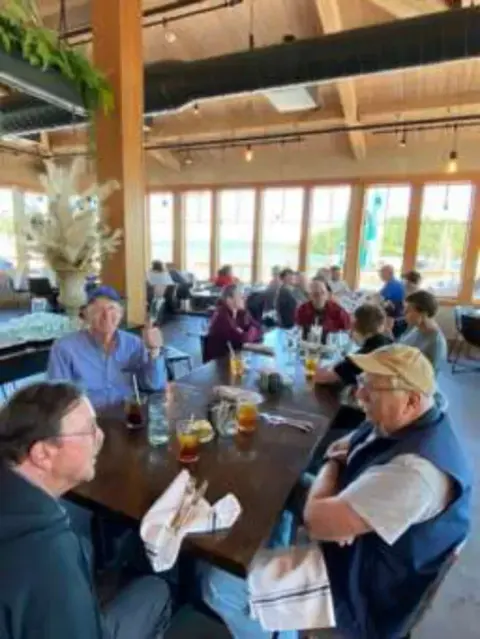 Pilots gathered around tables in an airport restaurant