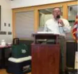 A man speaking into a microphone at a podium
