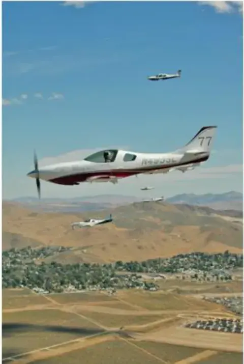 Race plane flying low over a valley with hills behind
