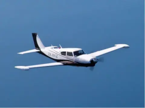 Low-wing airplane in flight over the sea