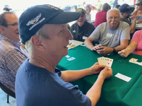 Man in a cap smiling at the poker table