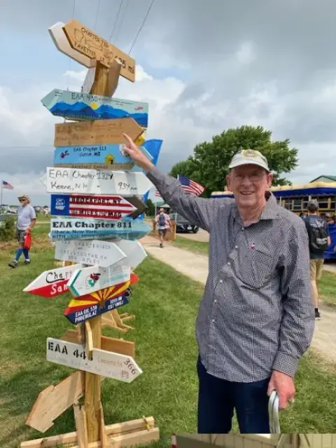 Barry points to the EAA directional sign posted in front of the building.