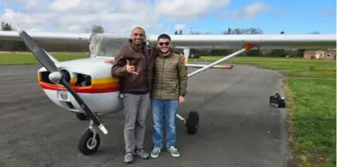 Two men standing by the nose of a Cessna on the ramp
