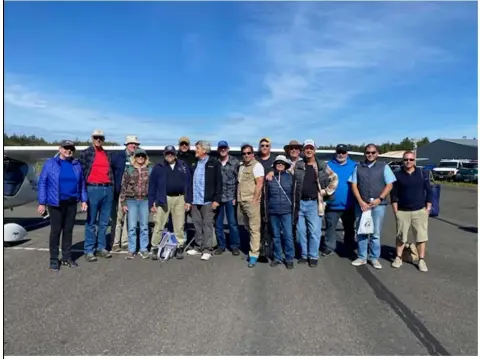 Large fly-out group lined up on the ramp in front of parked airplanes
