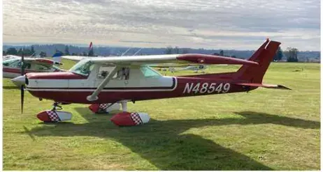 Red and white Cessna 152 N48549 parked on the grass