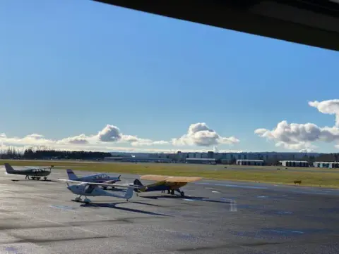 Small airplanes parked on the Arlington ramp under a blue sky