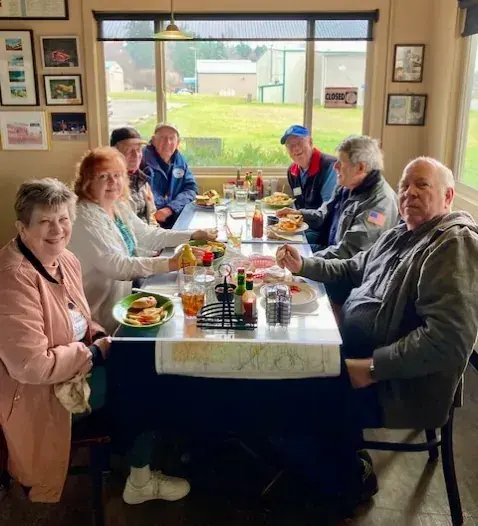 Chapter members seated at a long table having lunch