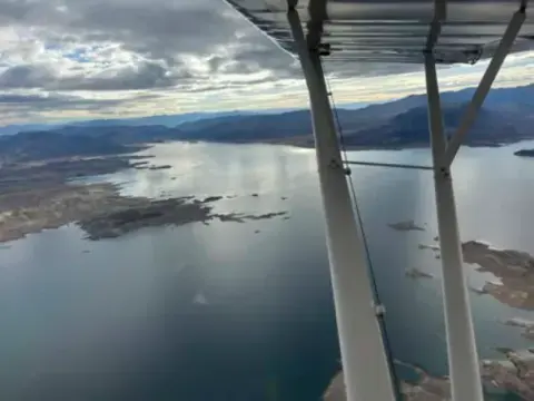 Aerial view of a lake from under the wing strut of a high-wing airplane
