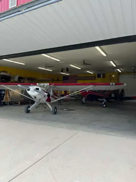 PA-11 parked inside a hangar