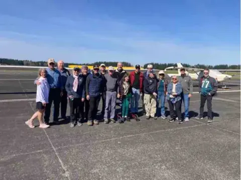 Group of fly-out participants posing on the ramp at Arlington