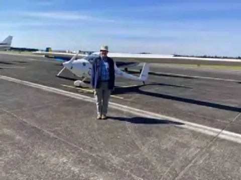 Two low-wing airplanes parked on the ramp at Arlington
