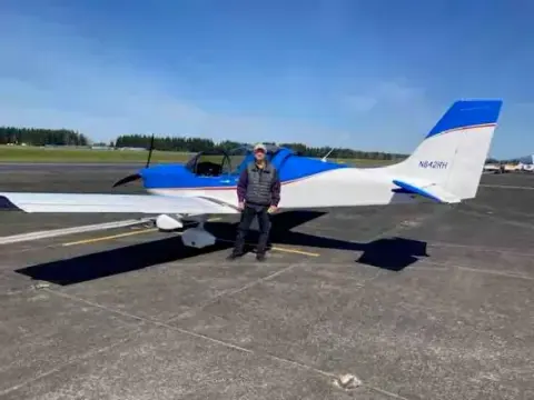 White and blue low-wing airplane parked on the ramp
