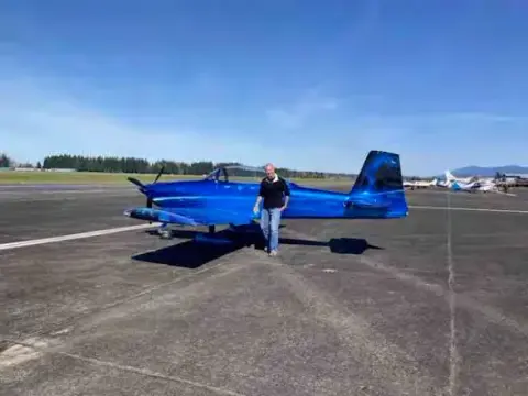 Blue and white low-wing airplane parked on the ramp