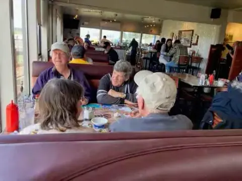 Fly-out group seated at tables in a restaurant
