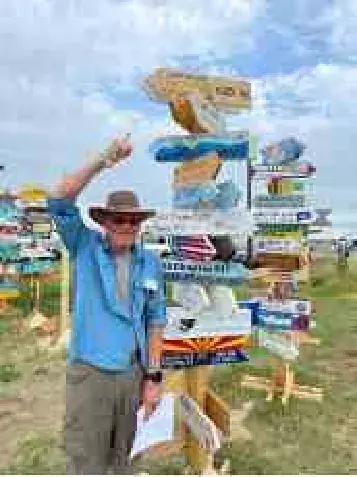 Man pointing at a signpost of destination arrows at a fly-in