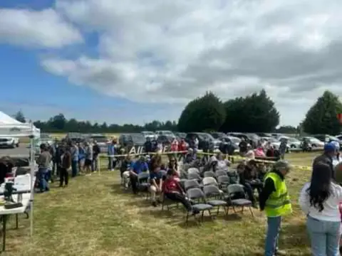 Crowd of families at the Young Eagles rally, with airplanes in the background
