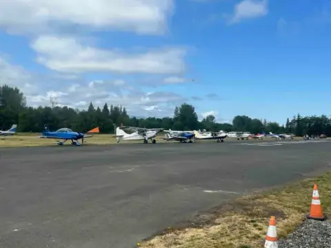 Line of airplanes parked along the runway at the Young Eagles rally