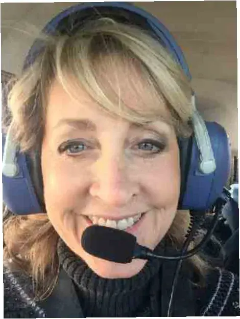 Smiling woman pilot wearing a headset in the cockpit
