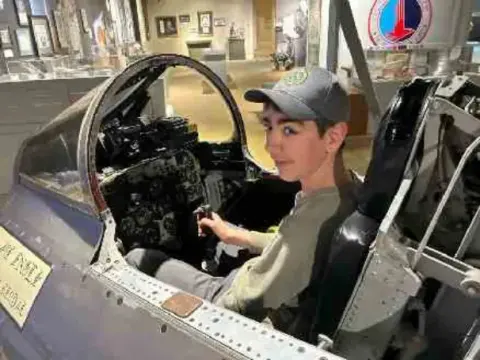 Teenage camper sitting in a jet cockpit trainer at EAA Air Academy
