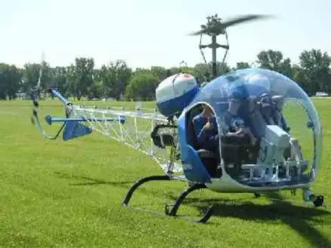 Small blue and white helicopter on the grass at EAA
