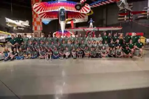 Large group of Air Academy campers in front of aircraft displays