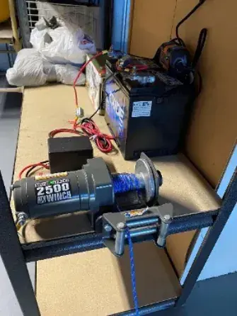 The electric tug stored on a shelf with its battery