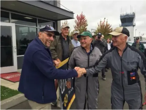 Men shaking hands on an airport ramp