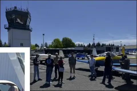Group of members on the ramp near a control tower