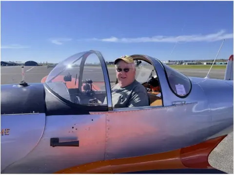 Pilot seated in the cockpit of a small airplane