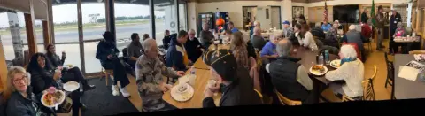 Members seated at tables during a gathering