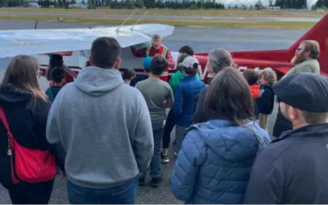 Families listening to a briefing on the ramp