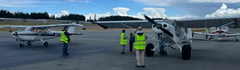 Airplanes and volunteers on the flight line under a big sky