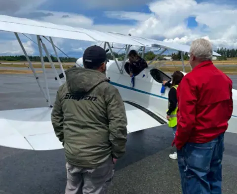 Steve with his Hatz biplane on the ramp, talking with a visitor