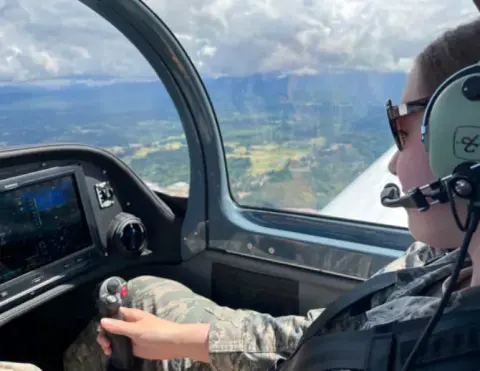 A Young Eagle wearing a headset at the controls during a flight