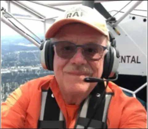 Smiling pilot wearing a headset in the cockpit