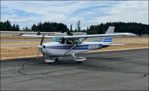A white Cessna 172 with blue stripes taxiing out with Young Eagles aboard