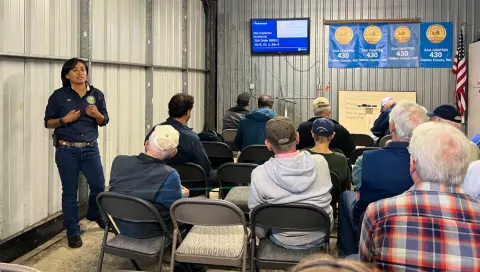 Hilda Maurera of the Seattle FAA Safety Team speaking to members seated in a hangar