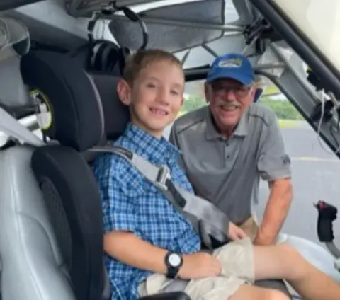 A young pilot and an instructor smiling in the cockpit