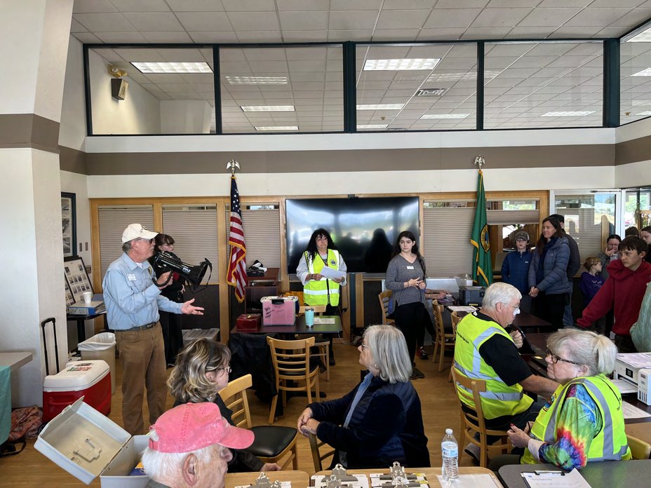Ray Ballantyne speaking to volunteers and families in a meeting room