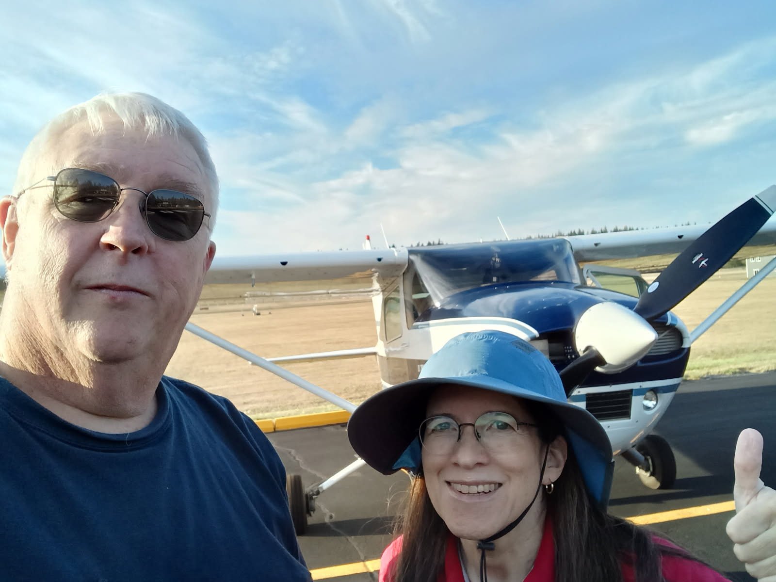 Kevin Tracy and DPE Cecilia Aragon smiling in a selfie in front of an airplane