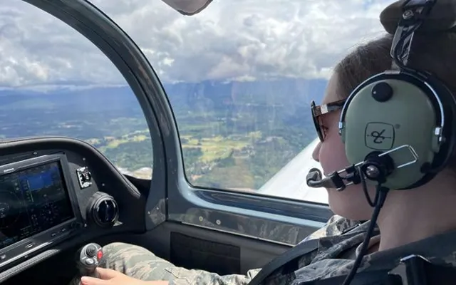 A Young Eagle wearing a headset at the controls during a flight